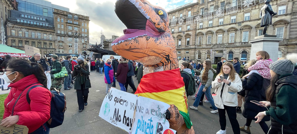  Активист в костюме динозавра принимает участие в демонстрациях на конференции по климату в Глазго, Шотландия.